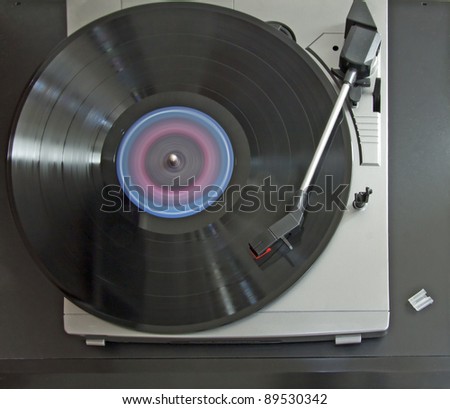 Closeup of spinning vinyl over a gray turntable