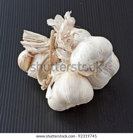 Some garlic heads over a black background
