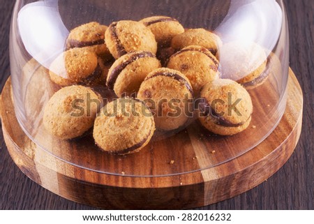 Baci di dama biscuits under glass bell jar, horizontal image