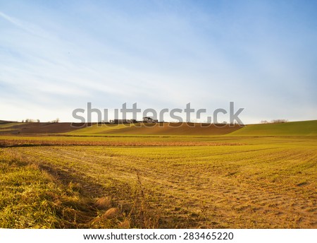 Fields and hills under sunset light, horizontal image