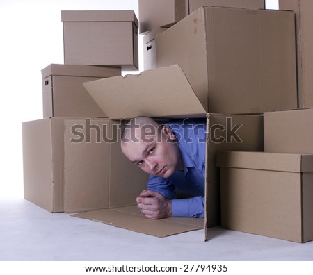 man in blue shirt looking out of cardboard box