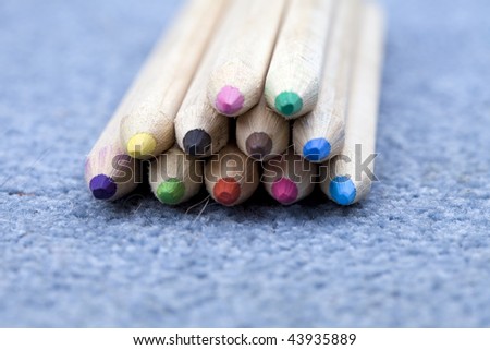Wooden, colored pencils crayons on the blue carpet