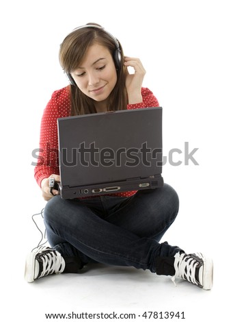 sitting on the floor young girl working on laptop and listening music from mp3 player