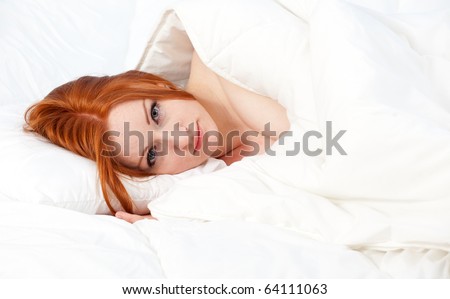 beautiful young woman relaxing in white bedding