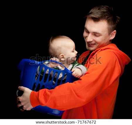 portrait of young father holding its lovely six months old son, black background