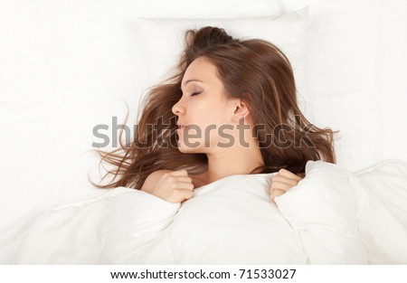 beautiful young woman sleeping in white bedding