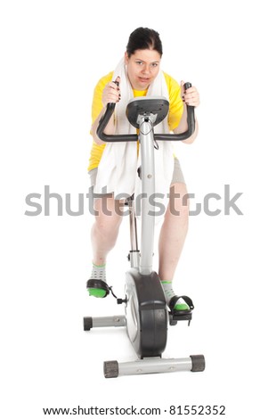 overweight woman in yellow shirt on stationary fitness bicycle, series