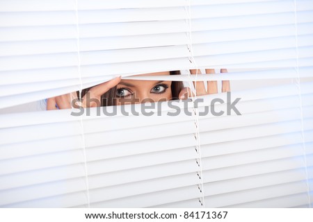 curious young woman is waiting with hope near window