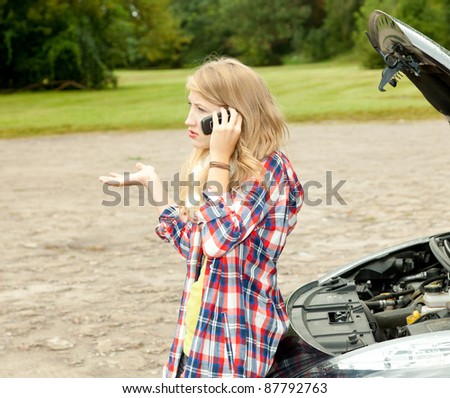 trouble with the car engine in the road, young woman phoning to help