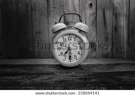 Retro alarm clock on the old wood background
