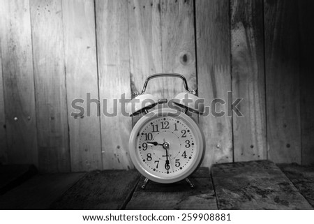 Retro alarm clock on the old wood background