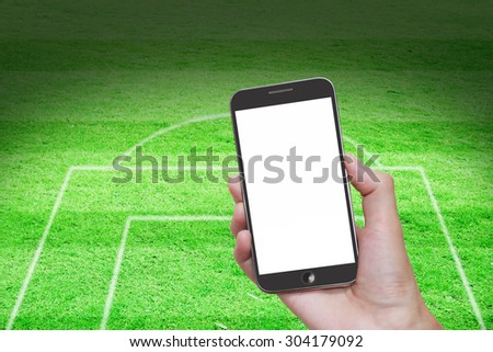 Man hand holding mobile smart phone with blank screen,football stadium background