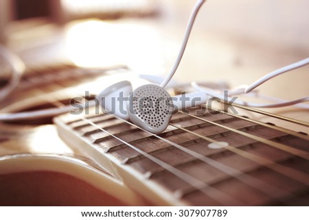 white earphone on the guitar,vintage retro