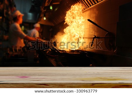 Empty dark wood table with fire gas burn is cooking on iron pan