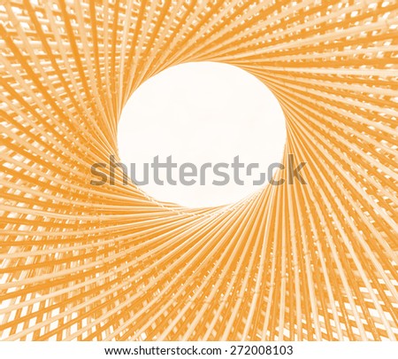 Weave pattern circle and hole in the middle of bamboo background process in tinted photo in orange tone