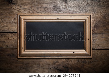 Old wooden frame with black blank. Free sheet for design or text