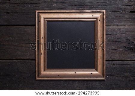 Sqare wooden frame with black paper on the old black wood background