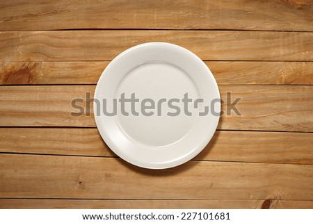 Empty Plate on wooden background. Top View with Text Space