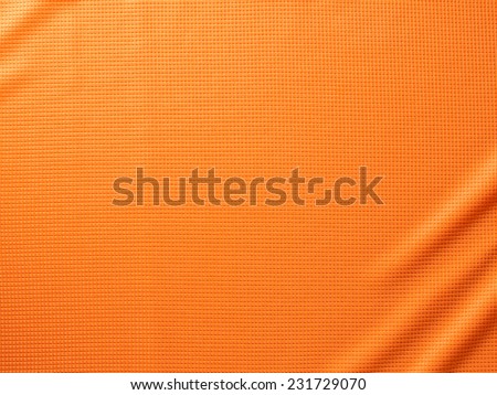 Sport Clothing Fabric Texture Background. Top View of Cloth Textile Surface. Orange Football Shirt. Text Space