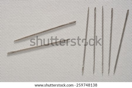 Sewing Needles on Cotton Fabric Background with Real Shadow. Top View with Copy Space for Text or Image
