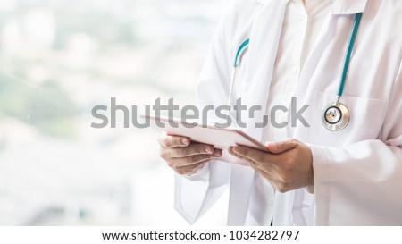 Medical doctor or physician holding mobile tablet for patient\'s health record in clinic or hospital office for professional online and emergency healthcare assistance service concept