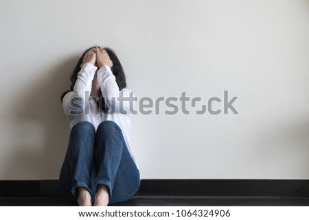 Anxiety disorder menopause woman, stressful depressed emotional person with mental health illness, headache and migraine sitting feeling bad sadly with back against wall on the floor in domestic home