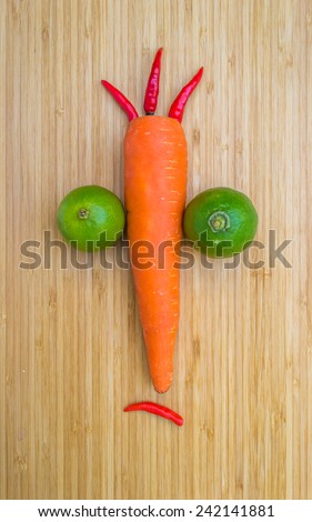 Sad-face vegetables on wooden board