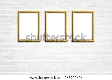 Three gold wooden frames on white brick wall