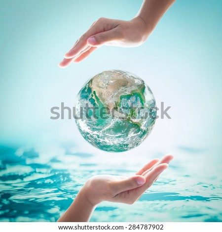 Green planet among female human hands on turquoise blue water background : World ocean and environment protection concept: Saving healthy oceans and planet: Elements of this image furnished by NASA