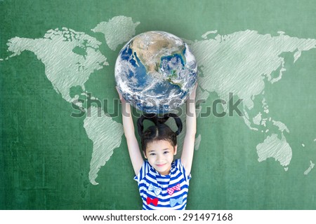 Happy Asian girl kid child raising hands holding globe on green chalkboard with world map background: Children\'s education for world literacy day concept : Elements of this image furnished by NASA