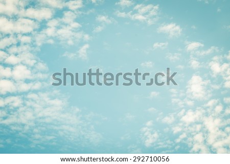 Vintage style blurred nature background of blue sky and soft scattered clouds with heart shaped empty space in the air in the middle : Holiday lovely blur puffy clouds with summer sky in retro style