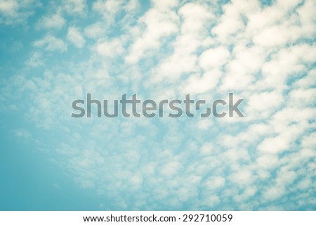 Vintage style blurred nature background of sky and soft scattered moving clouds with empty space in the air in the corner : Holiday lovely puffy clouds with summer sky in retro style