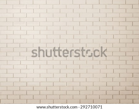 Brick wall tile texture background painted in antique sepia white color tone:Tiled brick wall in light sepia beige cream white tone