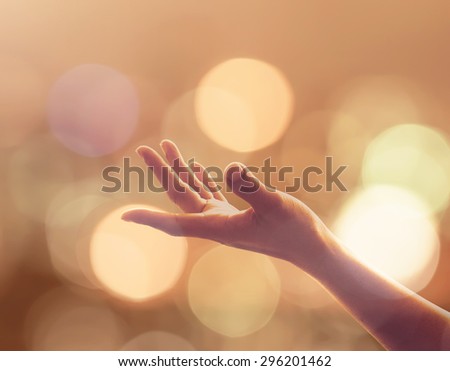 Empty female open human left hands with palms up and golden candle lights bokeh in natural warm gold color tone : Pray for spiritual support and helping concept : Night of power, novel, destiny