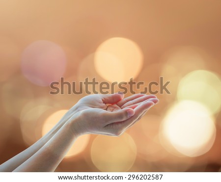 Empty female open human hands w/ palm up and golden candle light bokeh in natural warm gold color tone: Pray for spiritual support & helping concept: Night of power novel destiny: Prophet\'s birthday
