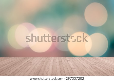Wooden floor in light red brown color tone with blurred abstract background of night city view with candle lights bokeh in cool vintage cyan blue green color tone for interior decoration