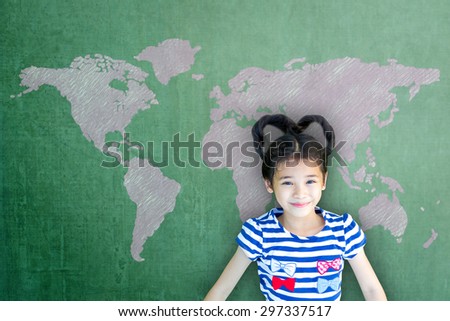 Happy Asian school child girl on green chalkboard with pink world map background: Smiling lovely female little kid with world map on  writable cement concrete backdrop in green color tone