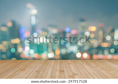 Wood floor in natural yellow brown color tone with blurred abstract background of Bangkok night lights downtown city view with bokeh with light flare : Wooden table with blur background of cityscape
