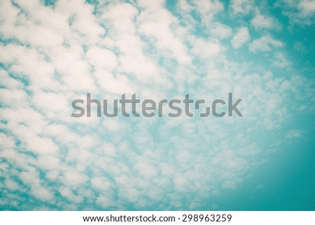 Paper texture background of retro style blurred sky with natural scattered clouds on wind movement: Water colour textured paper with blurry cyan blue windy dispersed cloudy sky in vintage color tone
