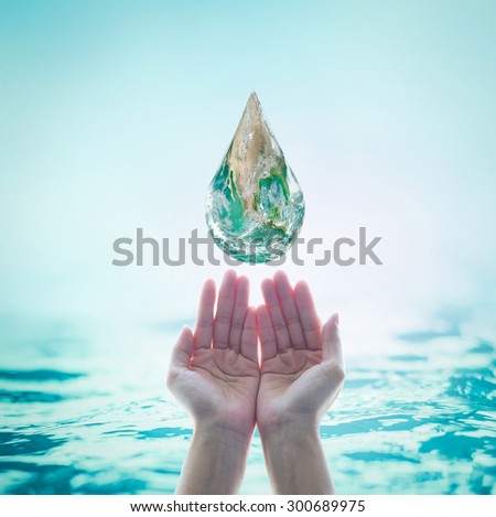 Isolated female hands save green planet water droplet on turquoise blue color water background: Saving world oceans, environment, ecosystems idea concept: Elements of this image furnished by NASA