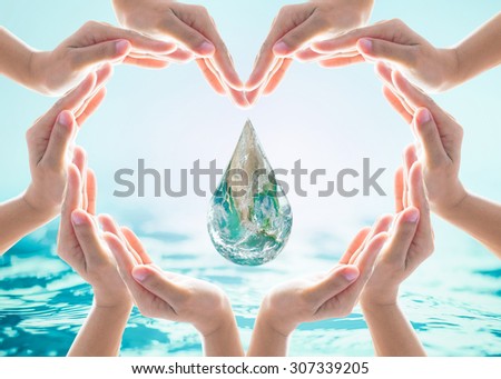 Collaborative human hands grouped in heart shape around blue water droplet earth globe: International cooperative, friendship and natural environment concept: Elements of this image furnished by NASA