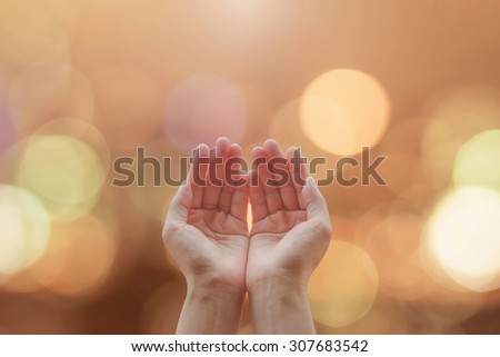 Empty female open human hands with palms up on blurred abstract background of candle lights bokeh in natural warm gold color tone : Destiny and pray for peace concept: Humanitarian aid