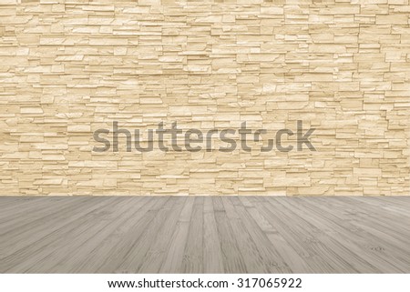 Limestone rock tile wall backdrop in yellow cream brown color tone with wooden floor in light sepia colour: Grunge vintage style room with rustic stone wall pattern background and wood flooring