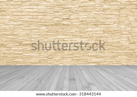 Limestone rock tile wall backdrop in yellow cream brown color tone with wooden floor in light grey colour: Grunge vintage style room with rustic stone wall pattern background and wood flooring