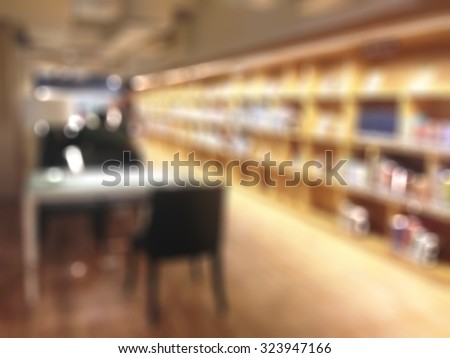Blurred abstract background of a view of aisle of book shelves in public library: Blurry interior perspective of a study room with tables, chairs and stacks of books: Blur educational interior