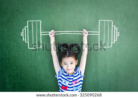 Happy healthy female kid doing weight lifting on grunge green chalkboard background: International day of girl child, equality and opportunity awareness on woman human rights, children's day concept