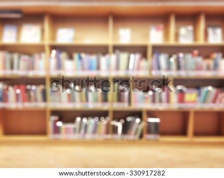 Blurred abstract background of public library interior with panel of bookshelves with collection of pocket books, magazines: Blurry perspective view of educational study room space with book shelves