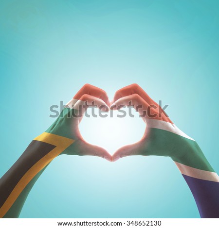 South Africa flag color pattern on woman human hands in heart shape on vintage sky background: Hand sign language symbolic concept of national unity, union, love for the nation and reconciliation