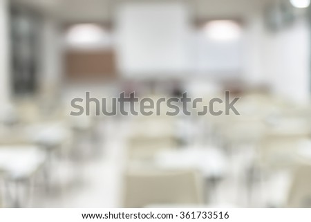 Blurred abstract background vacant empty seat row in school class lecture room w/ white projector slide screen in front: Blurry interior view back of the education classroom, no teacher nor student
