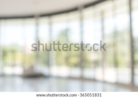 Blur abstract background exterior view looking out toward to empty office lobby and entrance doors/ glass curtain wall with frame: Blurry perspective of reception hall to public building entrance
